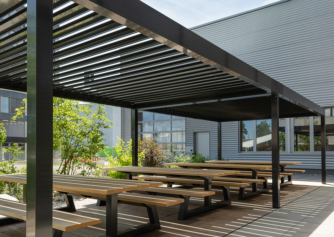 Großzügige Pergola mit Lamellendach über Sitz- und Picknickbereich, robuste Aluminium-Terrassenüberdachung für Außenflächen im gewerblichen Bereich vom Fachhändler in Trier, Konz und Luxemburg