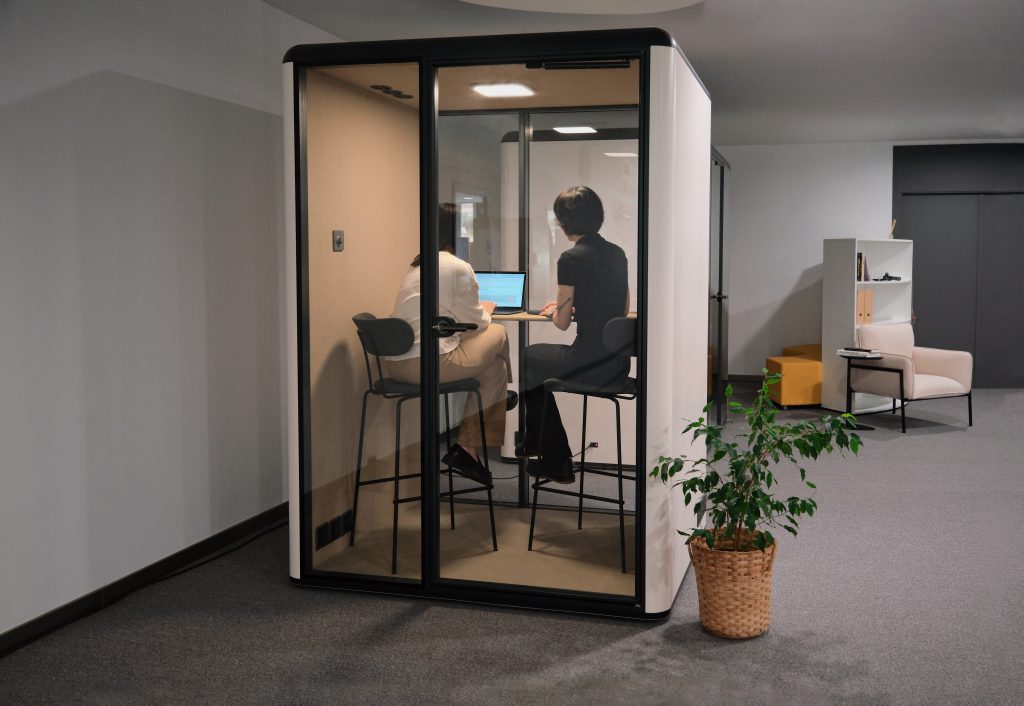 Zwei Personen arbeiten gemeinsam in einer schallgedämmten Akustikbox für Meetings und konzentrierte Zusammenarbeit – moderne Büro- und Konferenzlösung für Unternehmen in Trier, Konz und Luxemburg