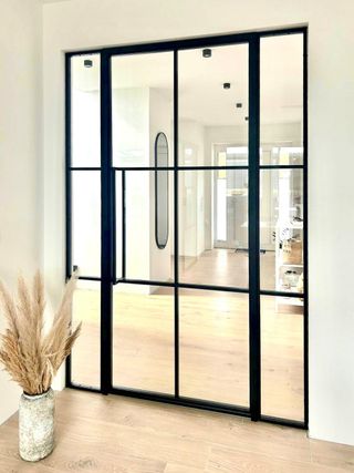 Moderne Glas-Innentür mit schwarzem Metallrahmen im Loft-Stil, elegante Raumtrennung mit viel Tageslicht, zeitloses Design für Wohn- und Arbeitsbereiche