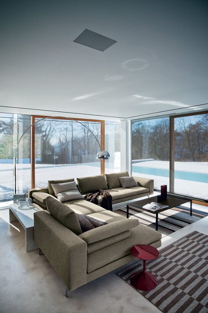 Moderne Designer-Wohnlandschaft mit großzügigem Sofa und Couchtisch vor bodentiefen Fenstern – exklusive Wohnmöbel für stilvolle Wohn- und Geschäftsräume in Trier, Konz und Luxemburg